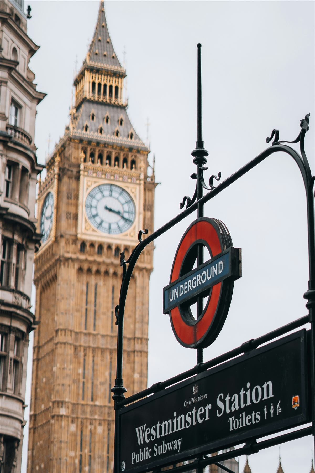 Westminster Underground station sign with Big Ben behind it, London