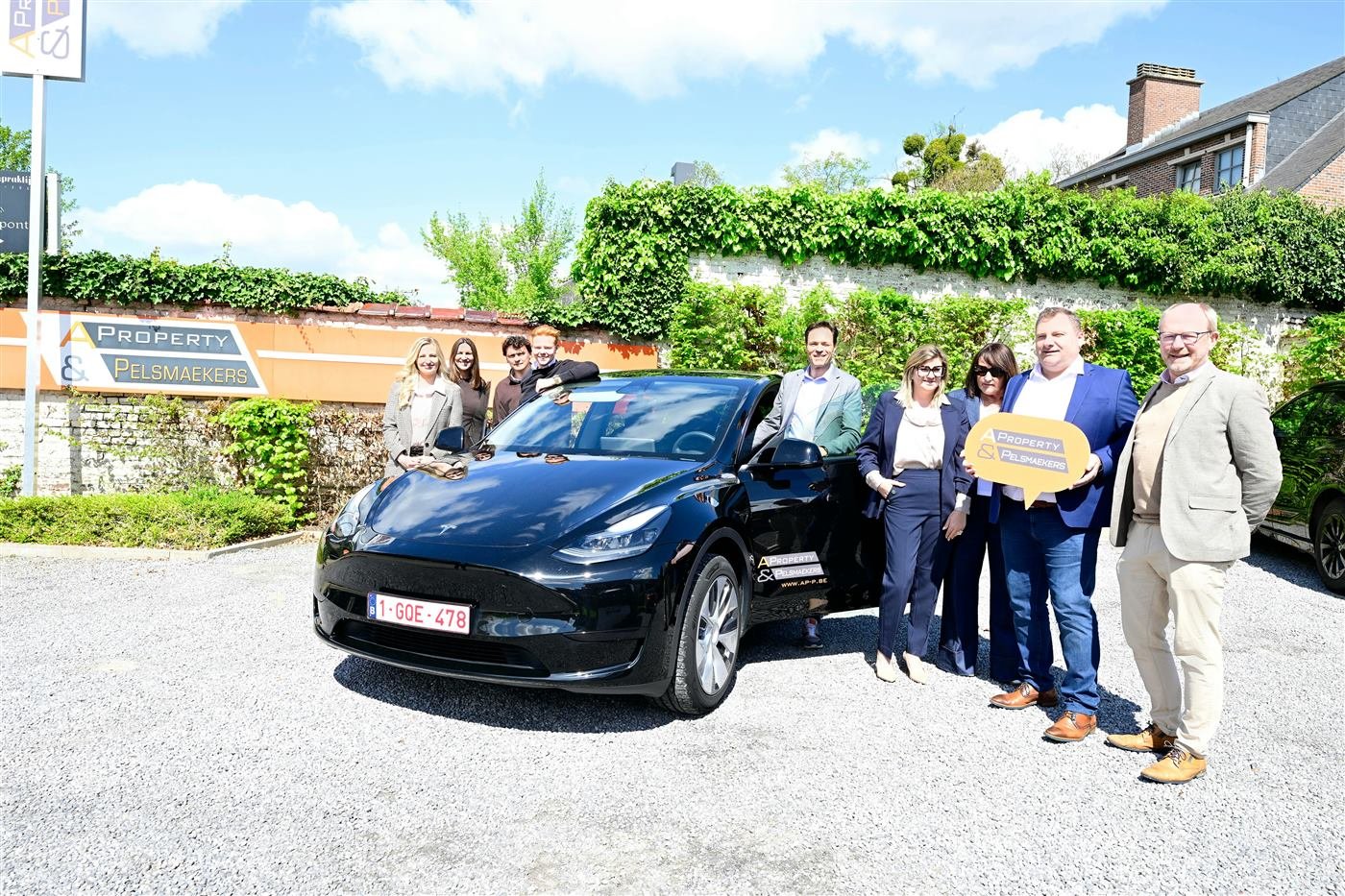 Team celebrating a new electric vehicle handover